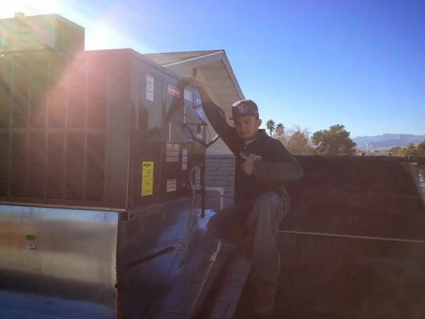 HVAC technician performing Heat Pump Repair on a rooftop unit in Burlington